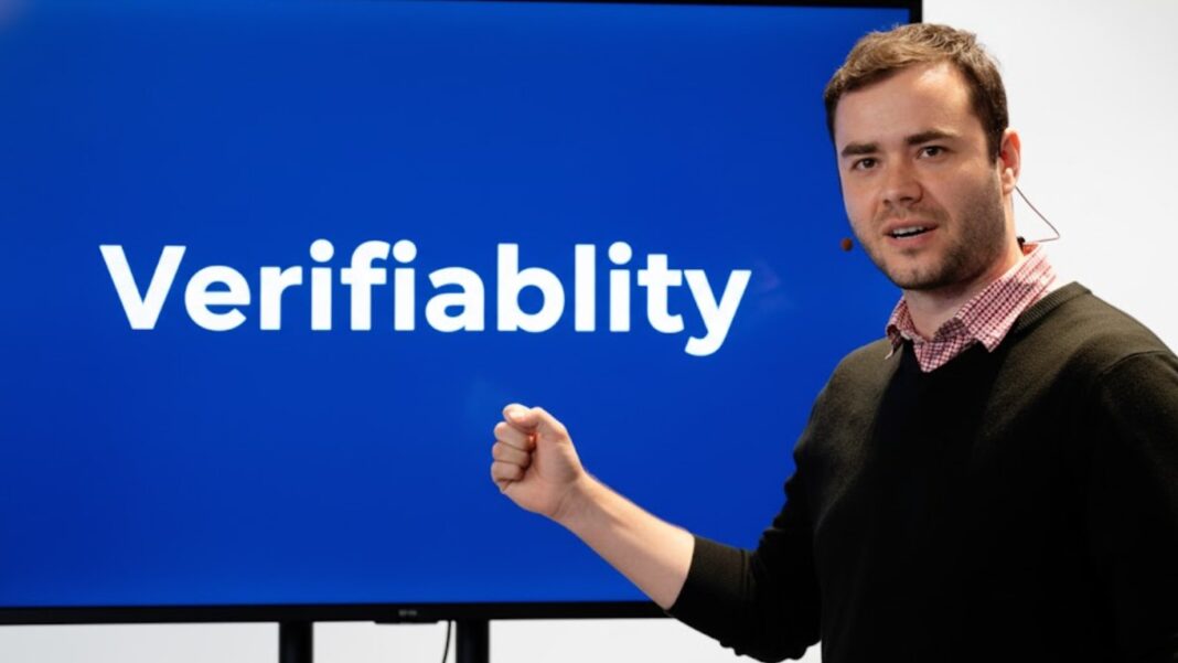 Andrej Karpathy points to a screen displaying the word ‘Verifiablity.’